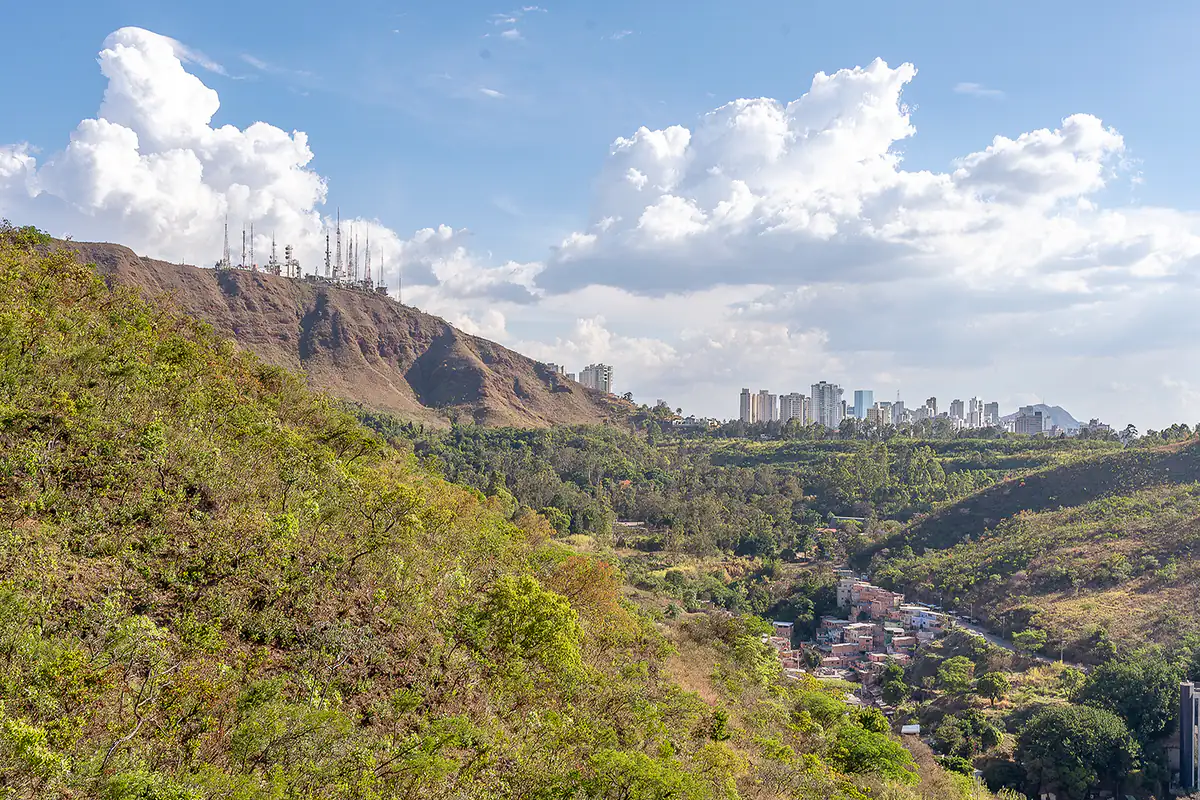 Skyline de prédios do bairro Belvedere em Belo Horizonte com a Serra do Curral ao fundo, sob céu com nuvens
