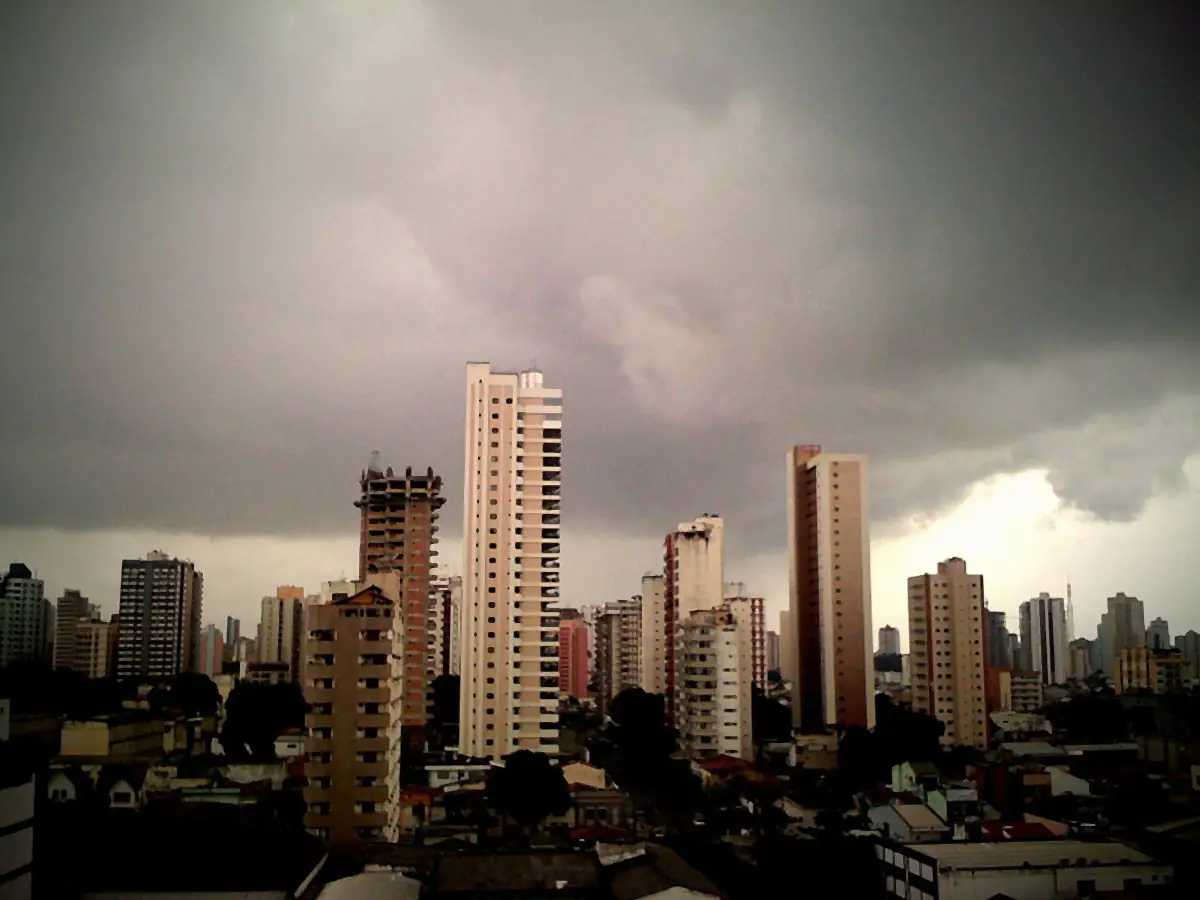 Prédios de Belém sob nuvens escuras de chuva, com uma faixa de céu claro no horizonte
