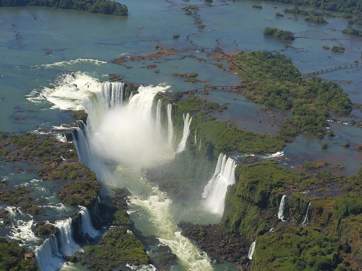 Vista aérea da Garganta do Diabo, nas Cataratas do Iguaçu, com névoa subindo da queda e a passarela ao fundo