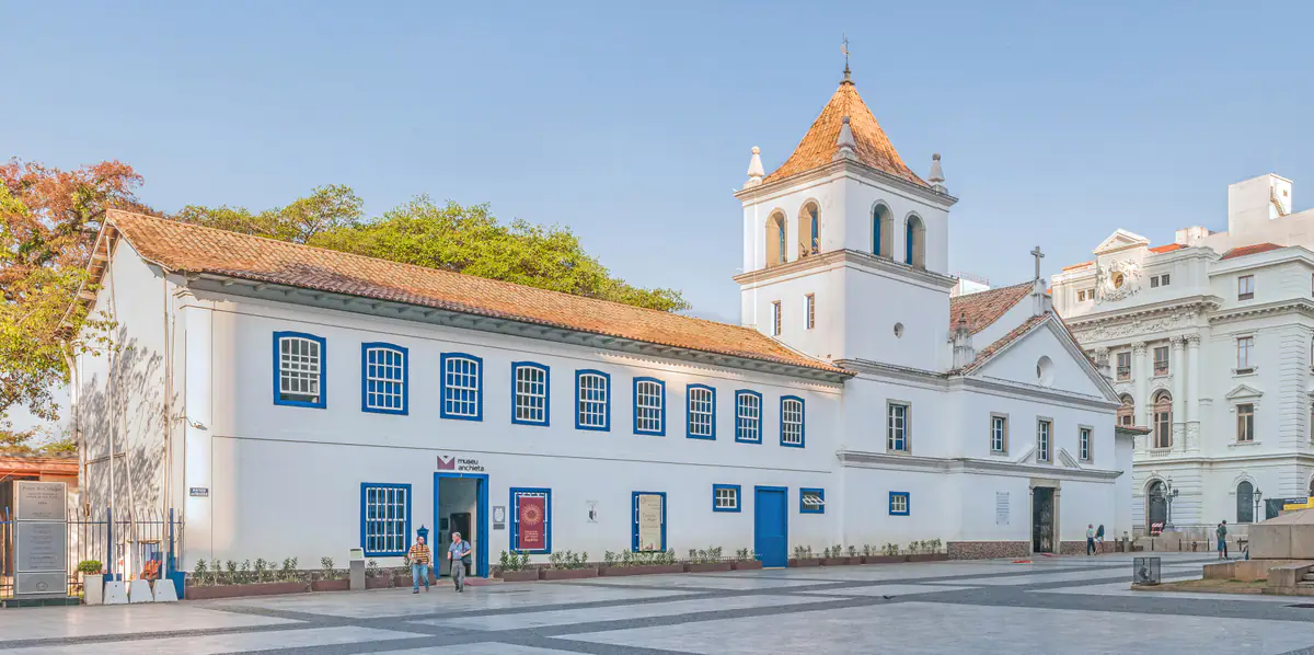 Pátio do Colégio, igreja e museu brancos no centro histórico de São Paulo, sob céu azul
