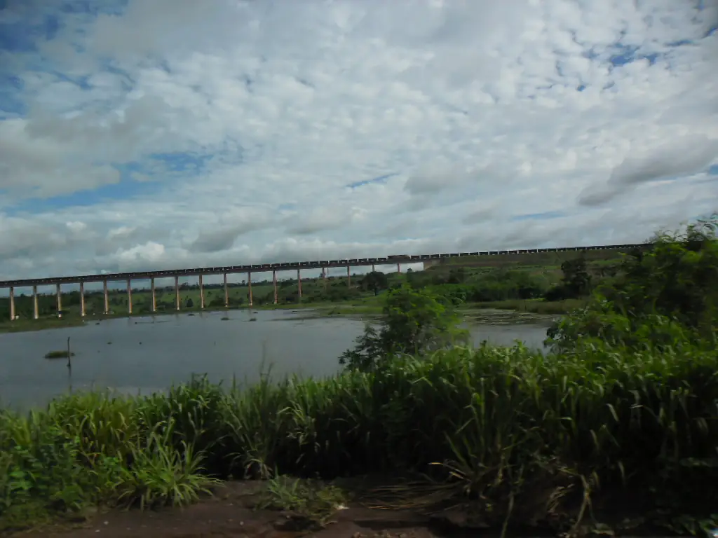 Viaduto da Estrada de Ferro Carajás sobre uma área alagada, sob céu carregado de nuvens, em Açailândia