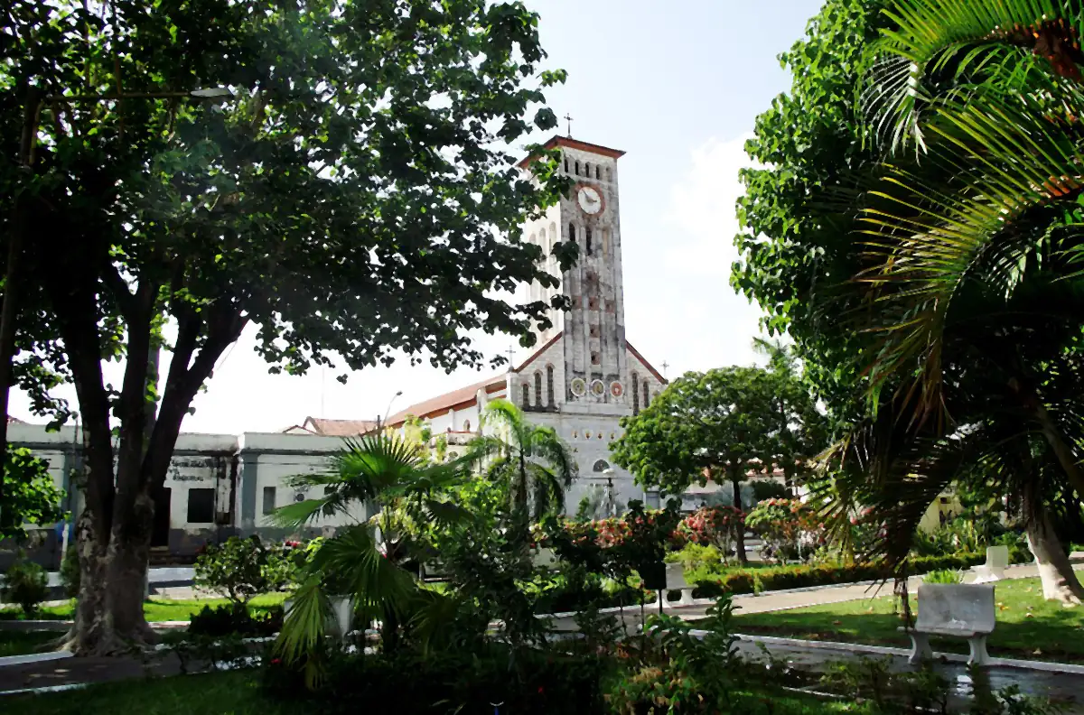 Igreja de Nossa Senhora da Conceição, em Barra do Corda, entre árvores e palmeiras, com céu claro