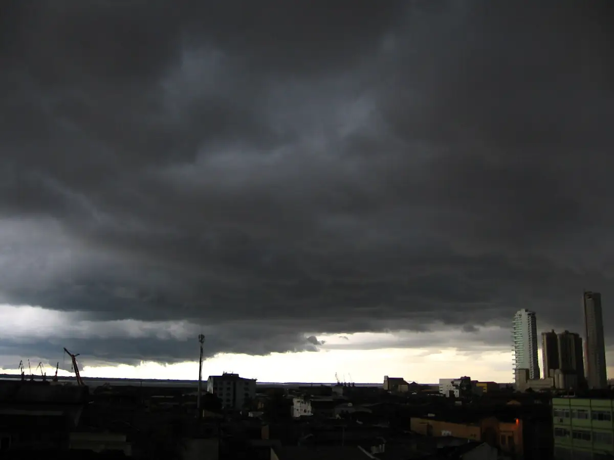 Nuvens escuras de temporal sobre os telhados e prédios de Belém, com uma faixa clara no horizonte