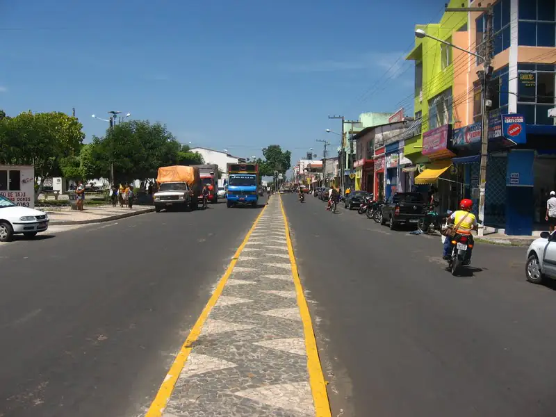 Avenida Oliveira Roma, no centro de Chapadinha, sob céu azul com poucas nuvens