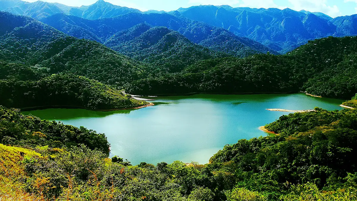 Represa cercada de mata fechada em Xerém, Duque de Caxias, com a Serra de Petrópolis ao fundo