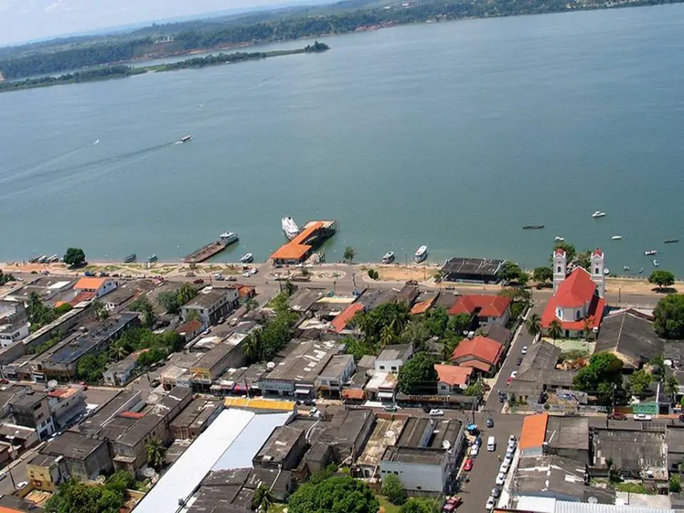 Vista aérea da orla de Itaituba, com o Rio Tapajós largo e cheio, barcos e uma igreja
