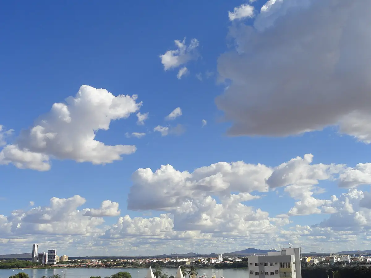 Rio São Francisco e a cidade de Juazeiro ao fundo, sob céu azul com nuvens carregadas