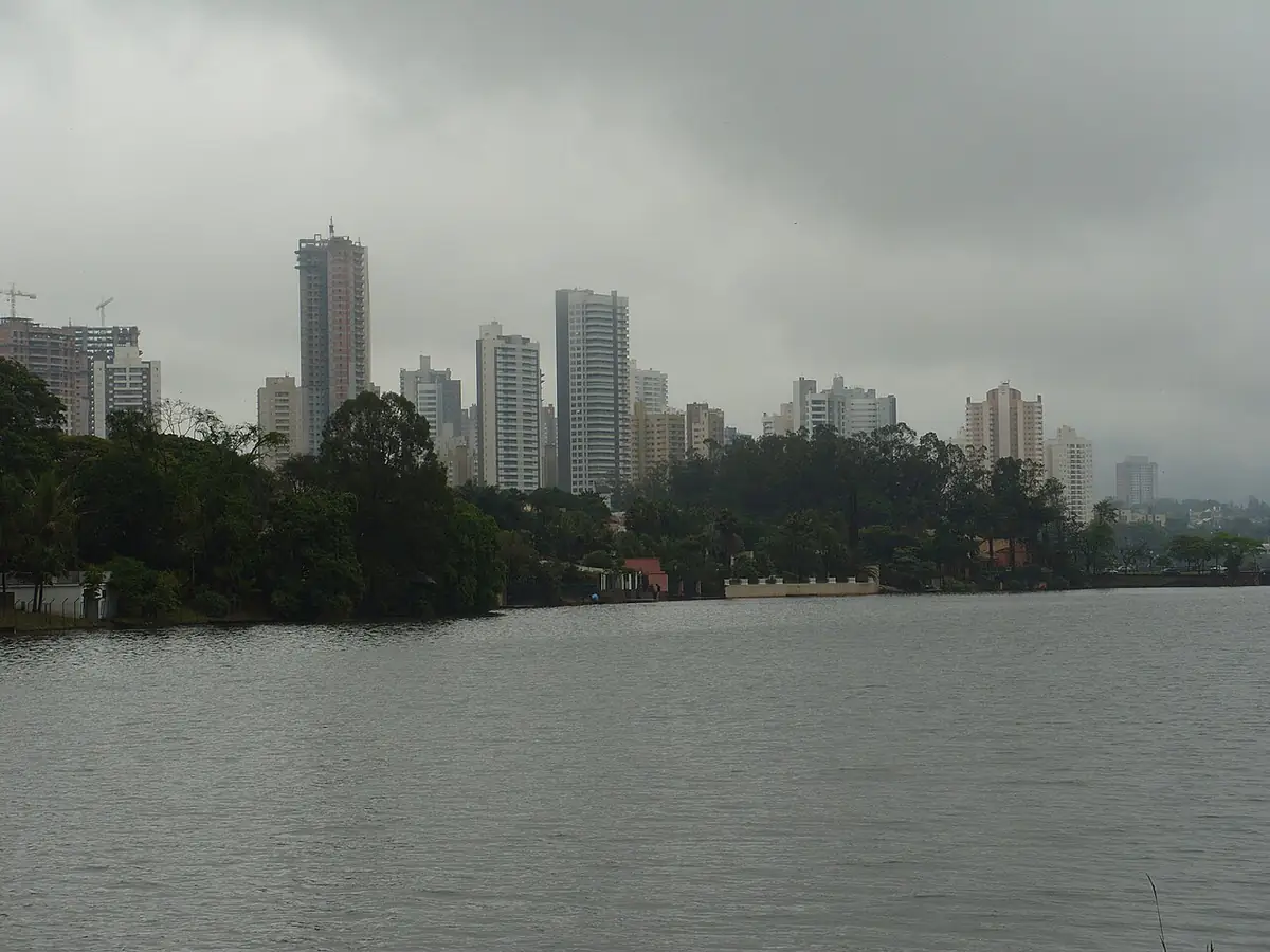 Prédios de Londrina atrás do Lago Igapó sob céu cinzento e nublado, em dia de chuva