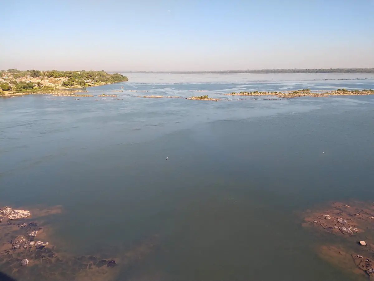 Pedrais aparecendo no Rio Tocantins em Marabá, com a cidade na margem e céu limpo