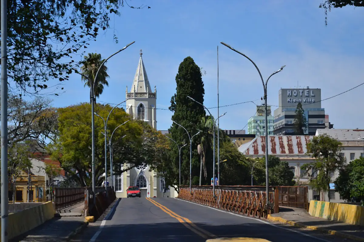 Ponte 25 de Julho sobre o Rio dos Sinos, com a torre da Igreja Matriz ao fundo, em São Leopoldo, sob céu azul