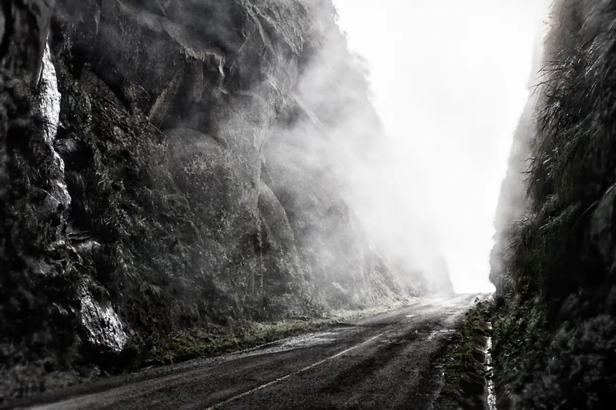 Estrada de serra entre paredões de rocha, tomada pela neblina, no caminho do Morro da Igreja em Urubici